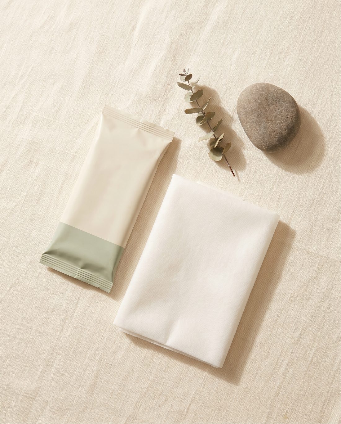 The Subway Sitter pouch and folded sheet with eucalyptus on warm linen